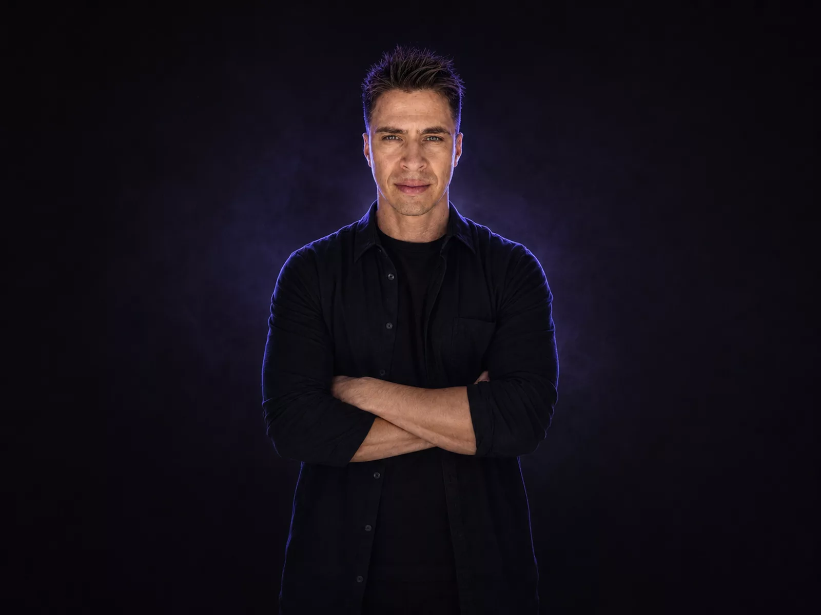 Ivan Guaderrama, arms crossed, violet studio haze