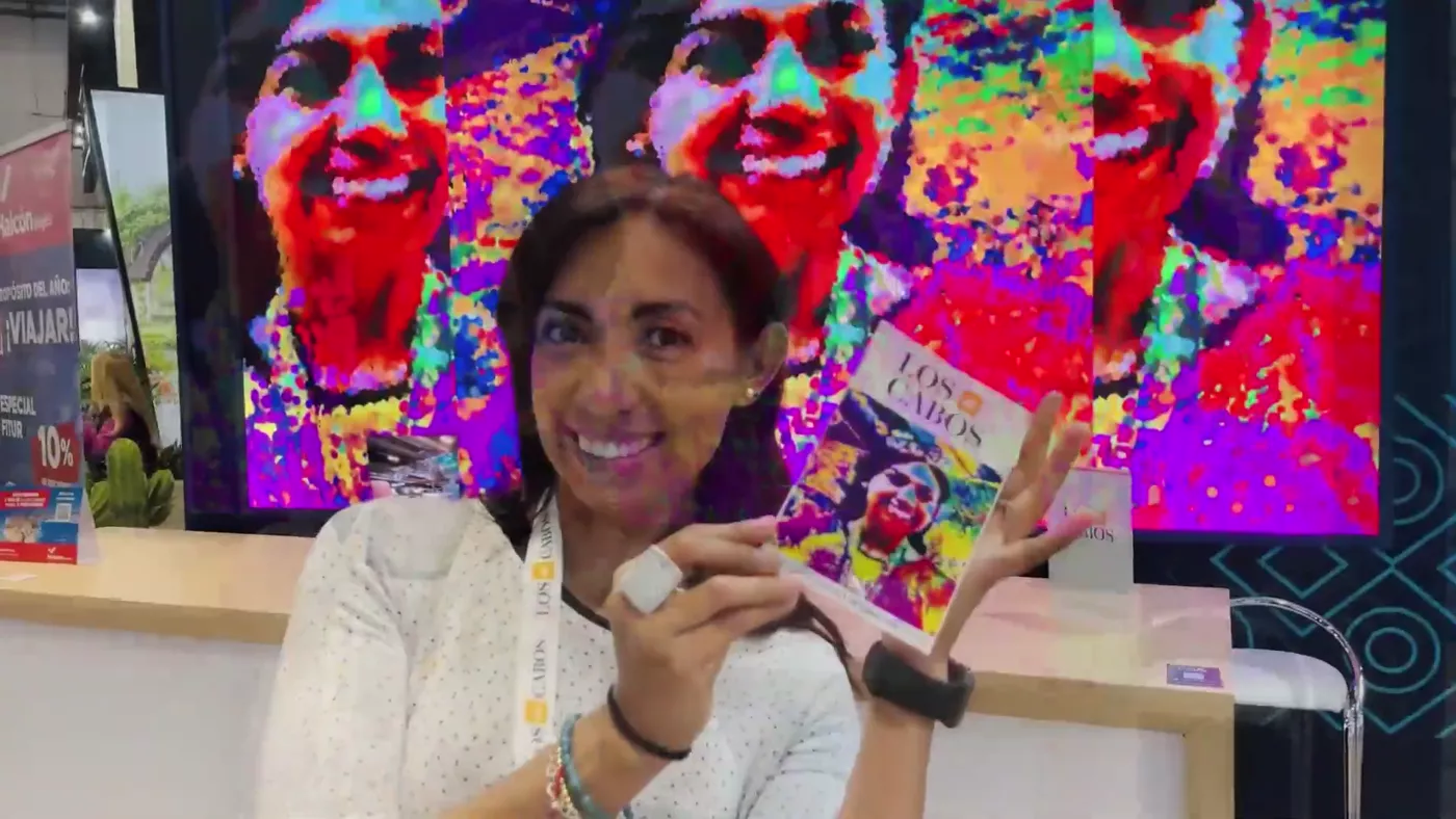 Visitor holding her printed portrait next to her giant pointillist portrait on the wall