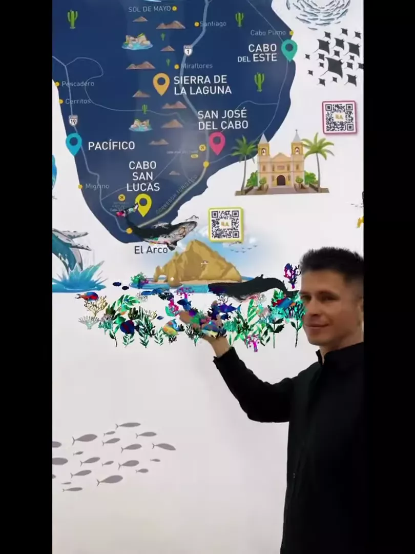 Visitor holding the illustrated Los Cabos map mural on his palm