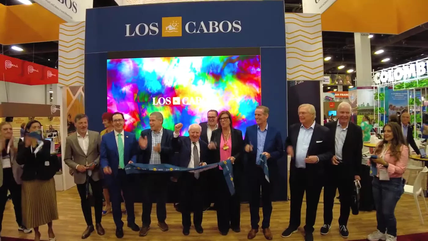 Delegates cutting the ribbon in front of the exploding color wall at IMEX